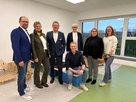 Sieben Personen stehen für ein Pressefoto im Bewegungsraum der KSB-Kita in Tudorf.