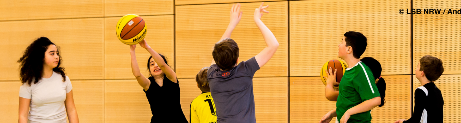Bild mit spielenden Kindern in einer Turnhalle
